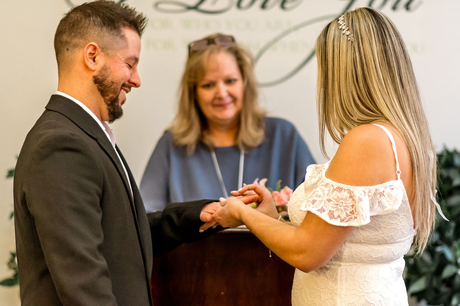 Wedding ceremony exchange of rings during intimate indoor ceremony.