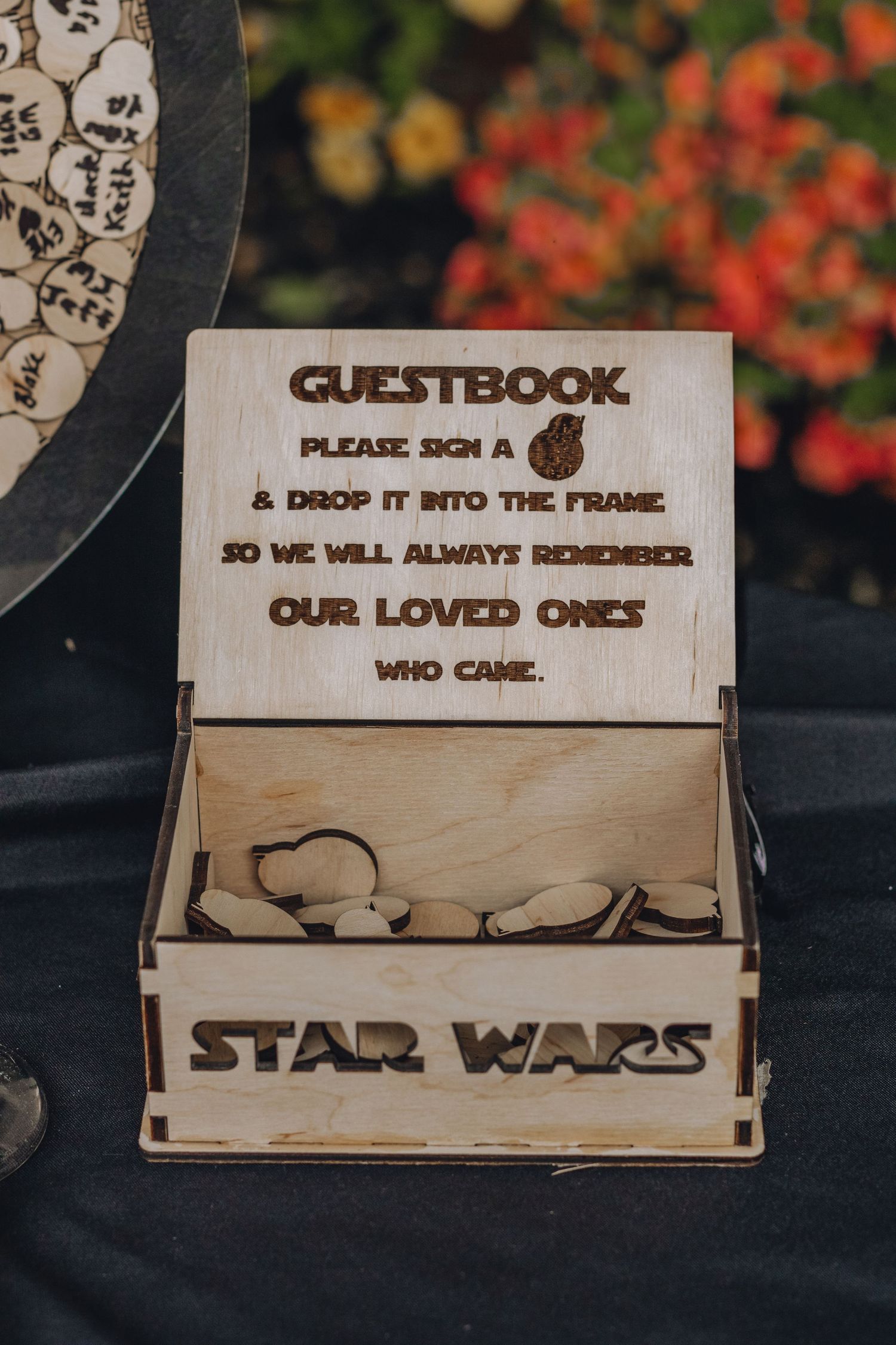 A wooden Star Wars themed guestbook box with hearts and instructions to sign and drop messages inside.