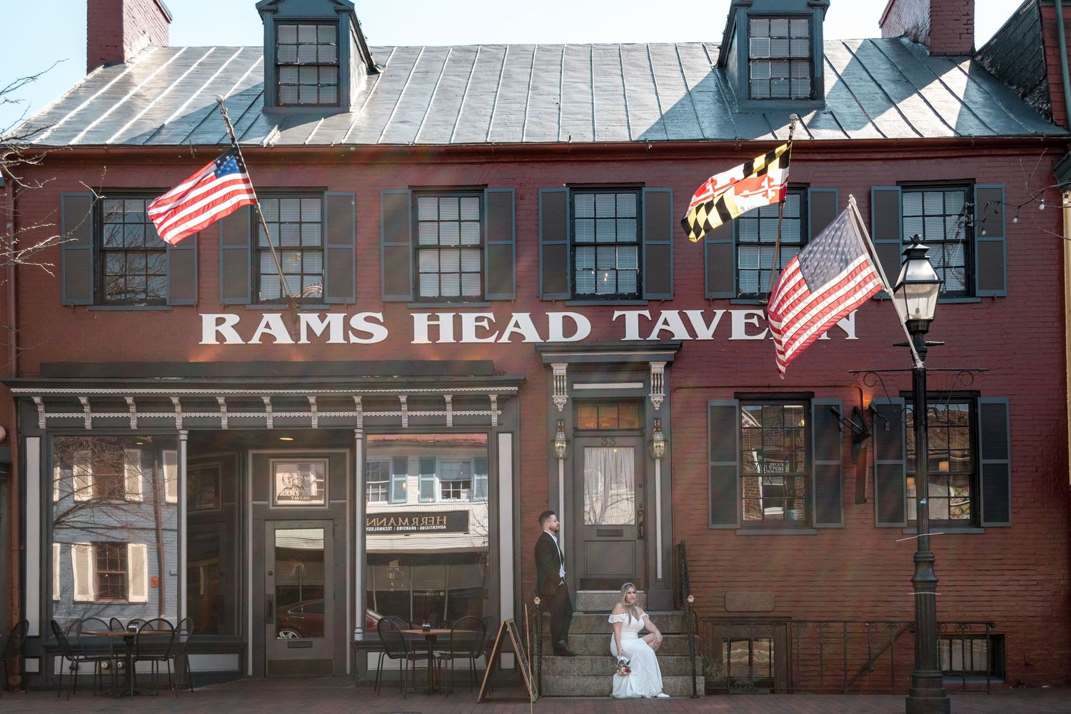 Historic Rams Head Tavern exterior with American flags and brick facade.