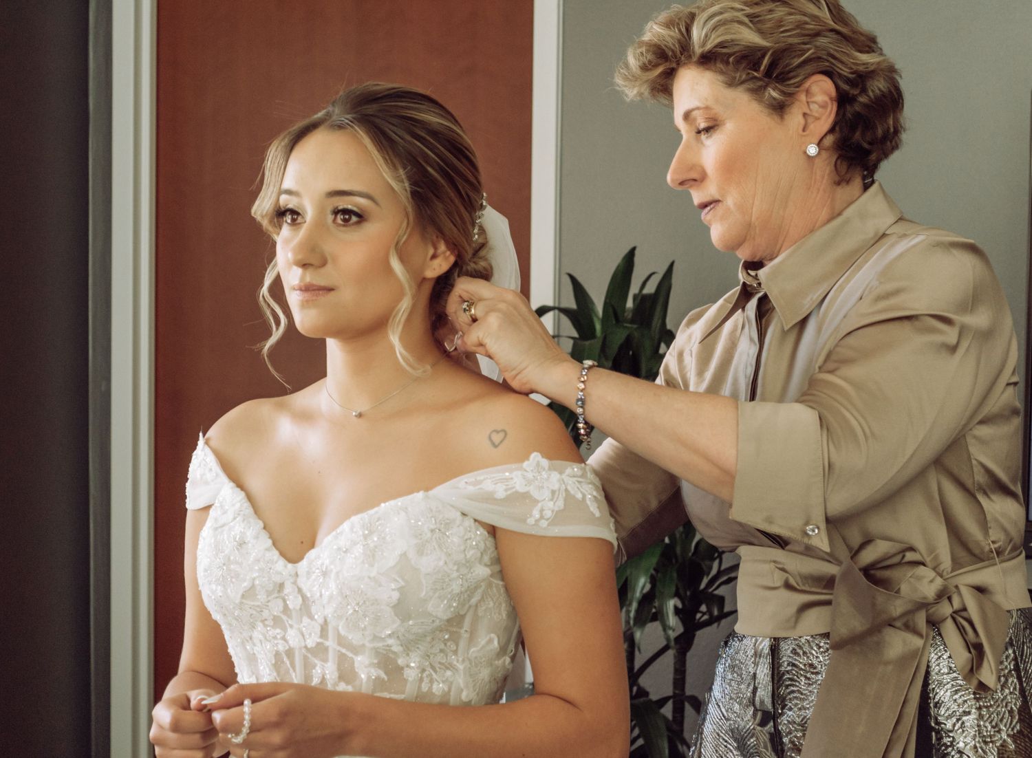 A series of wedding preparation photos showing bride getting ready with finishing touches to hair and dress details.