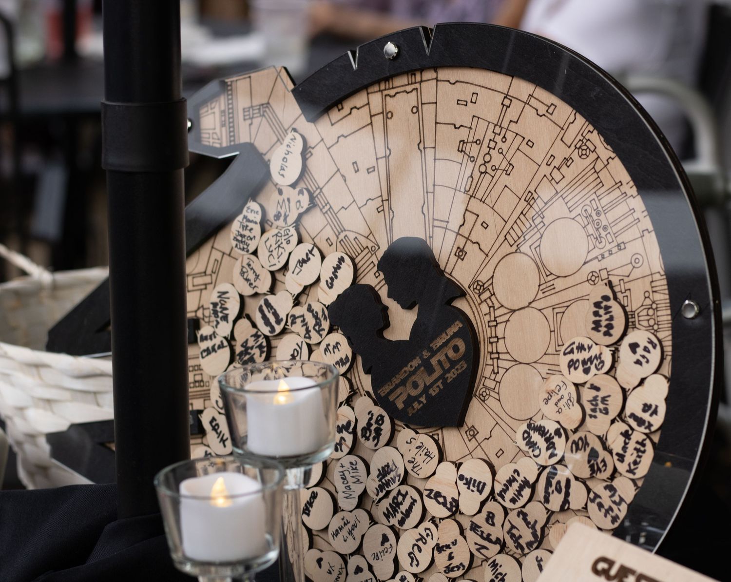 A decorative wooden clock face with ornate designs and lit tea light candles in the foreground.