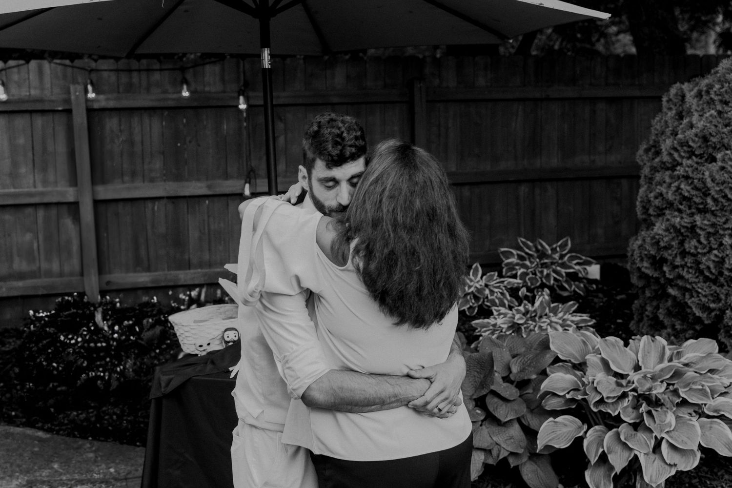 A vintage black and white collage of a couple dancing and embracing in various poses outdoors by a garden.