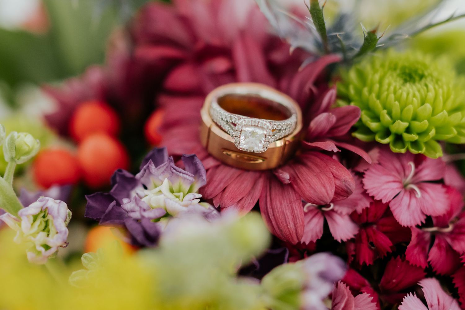 Pink and white wedding flowers with gold ring photographed in dreamy natural light.
