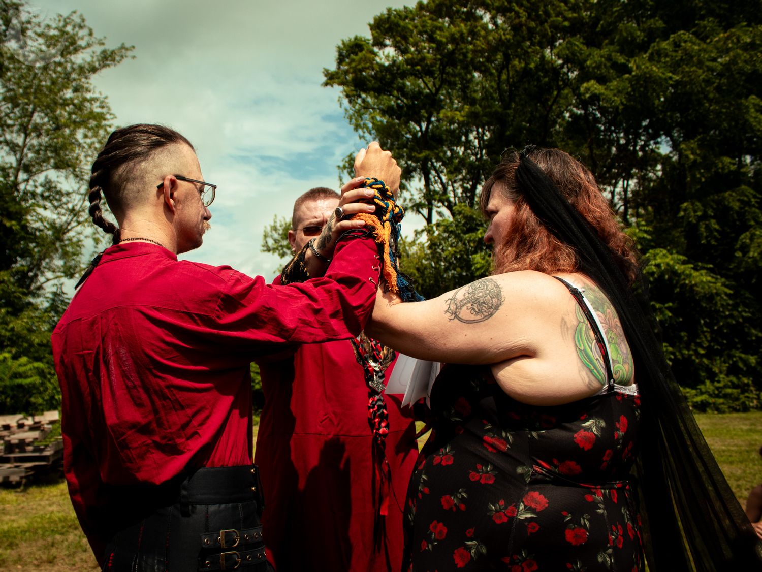 Group enjoying traditional mate drinks together in a park with green trees in background.