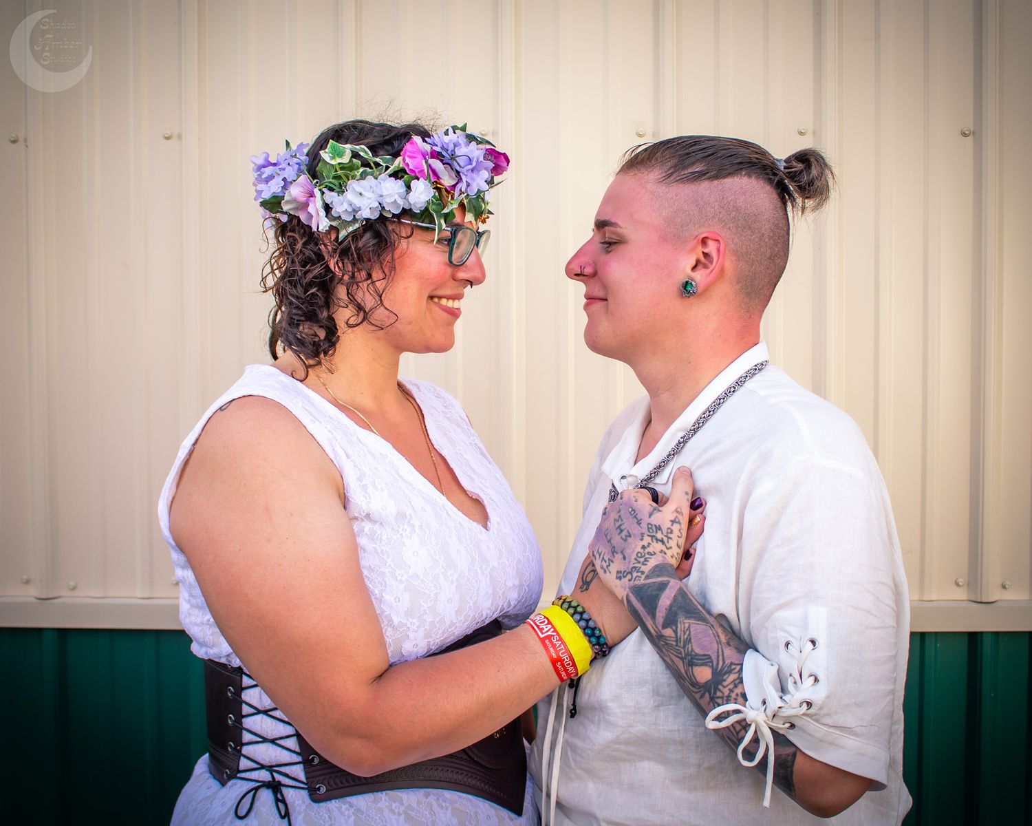 A couple shares an intimate moment at their wedding, with the bride wearing a floral crown and white dress.