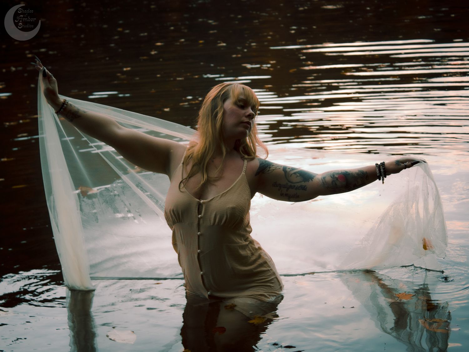 Dramatic pose with flowing fabric captured during a twilight water photography session.
