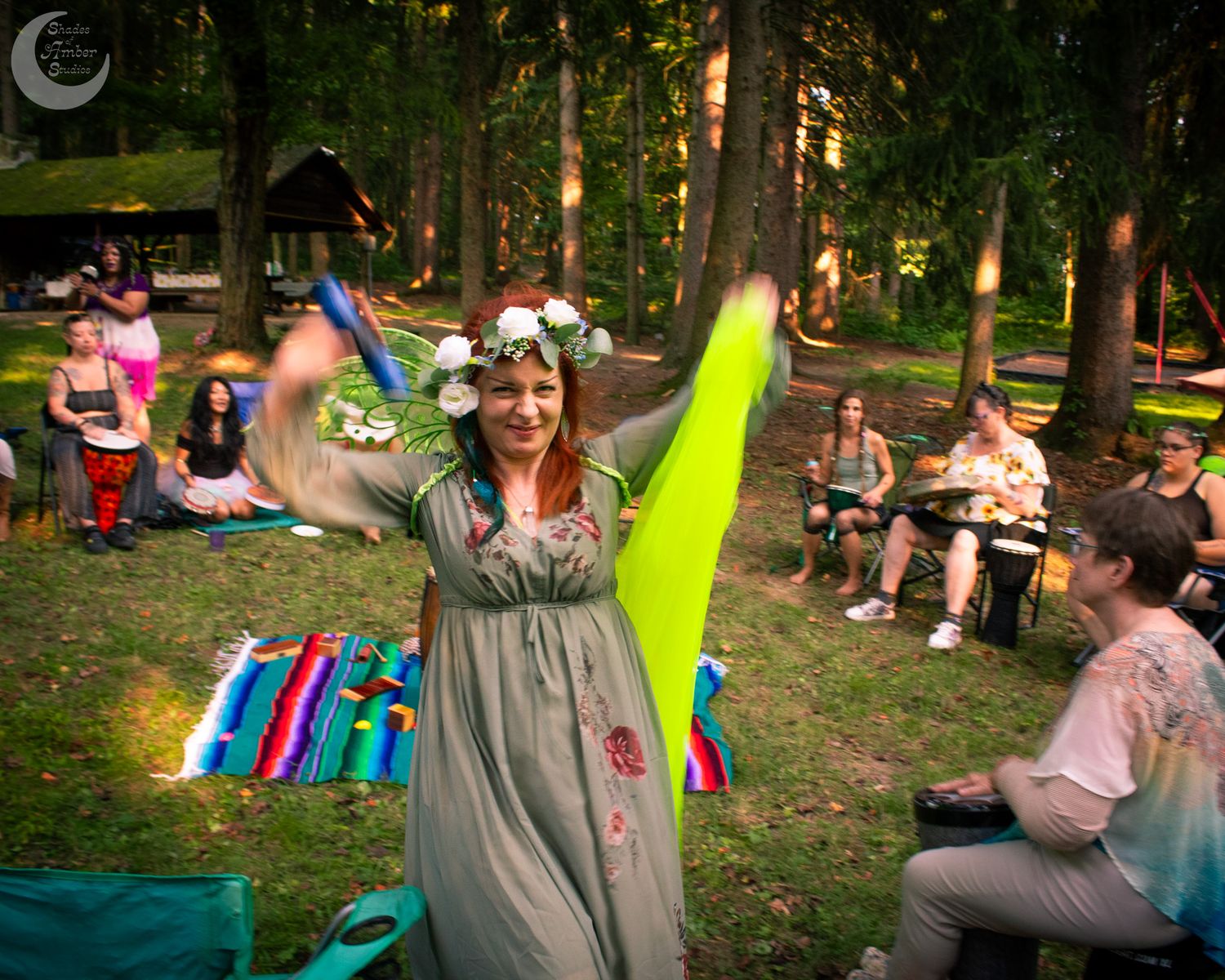 A joyful celebration in a wooded setting with colorful decorations and outdoor seating.