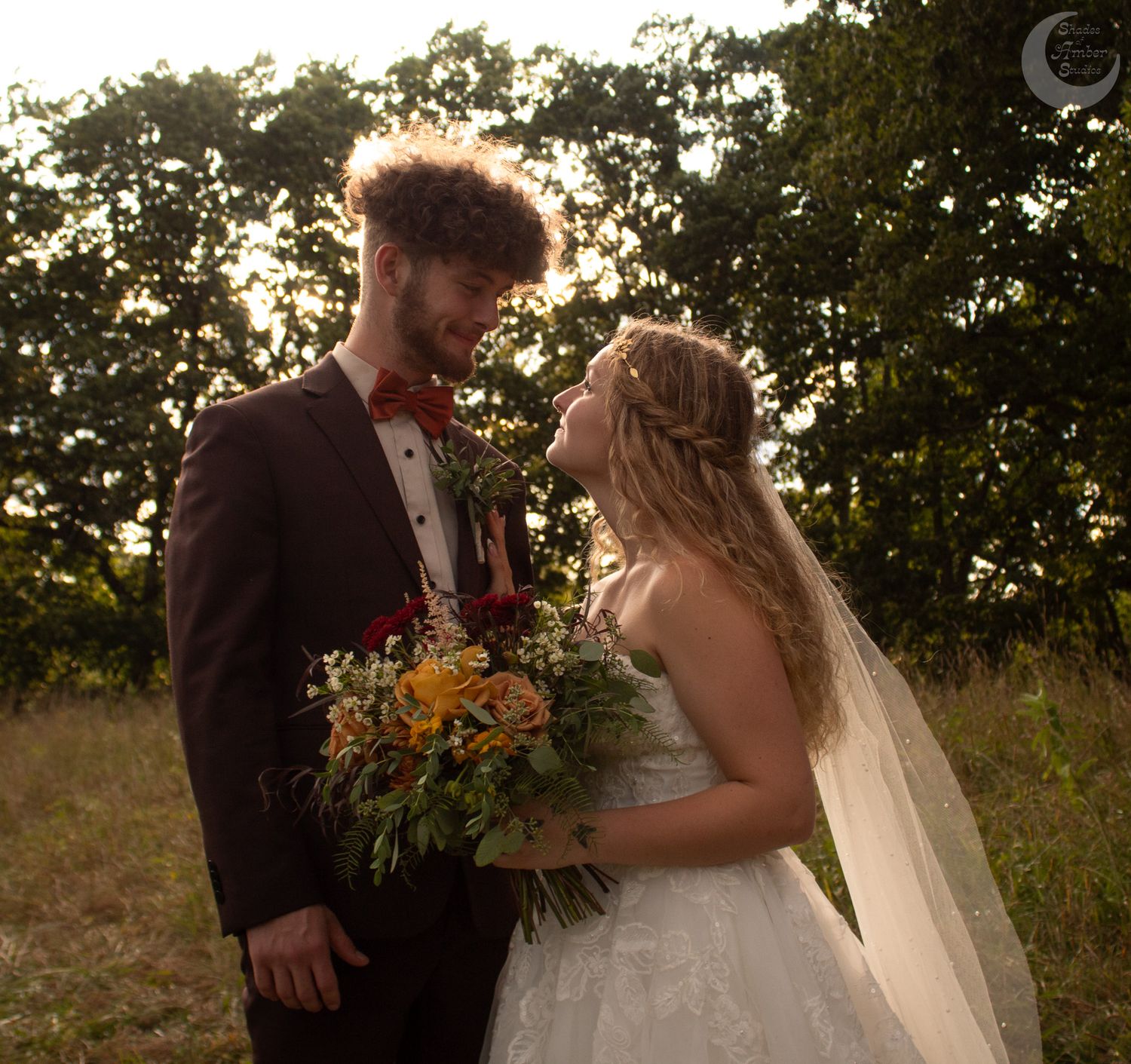 Newlyweds sharing intimate moments in a garden setting with autumn-colored florals at sunset.