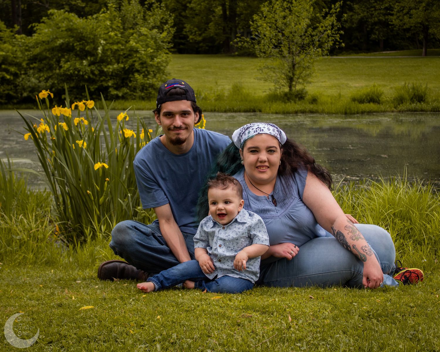 Family enjoying a relaxing day outdoors on grass with yellow wildflowers in the background.