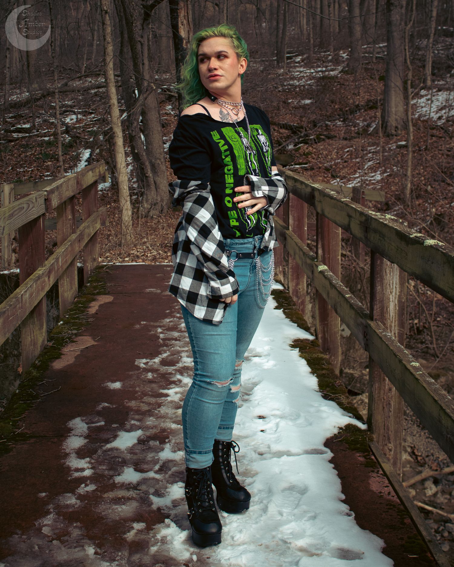 Winter fashion pose on wooden bridge with black and white flannel and graphic shirt.