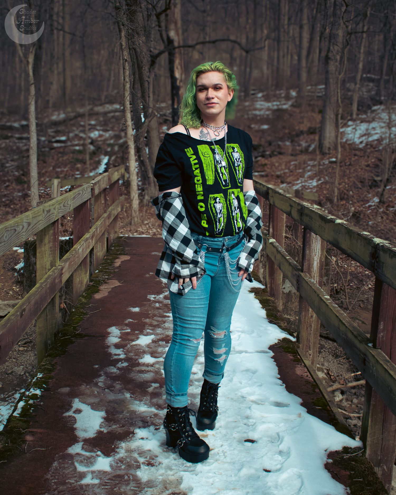 Alternative fashion look on snowy boardwalk with plaid flannel and graphic tee.