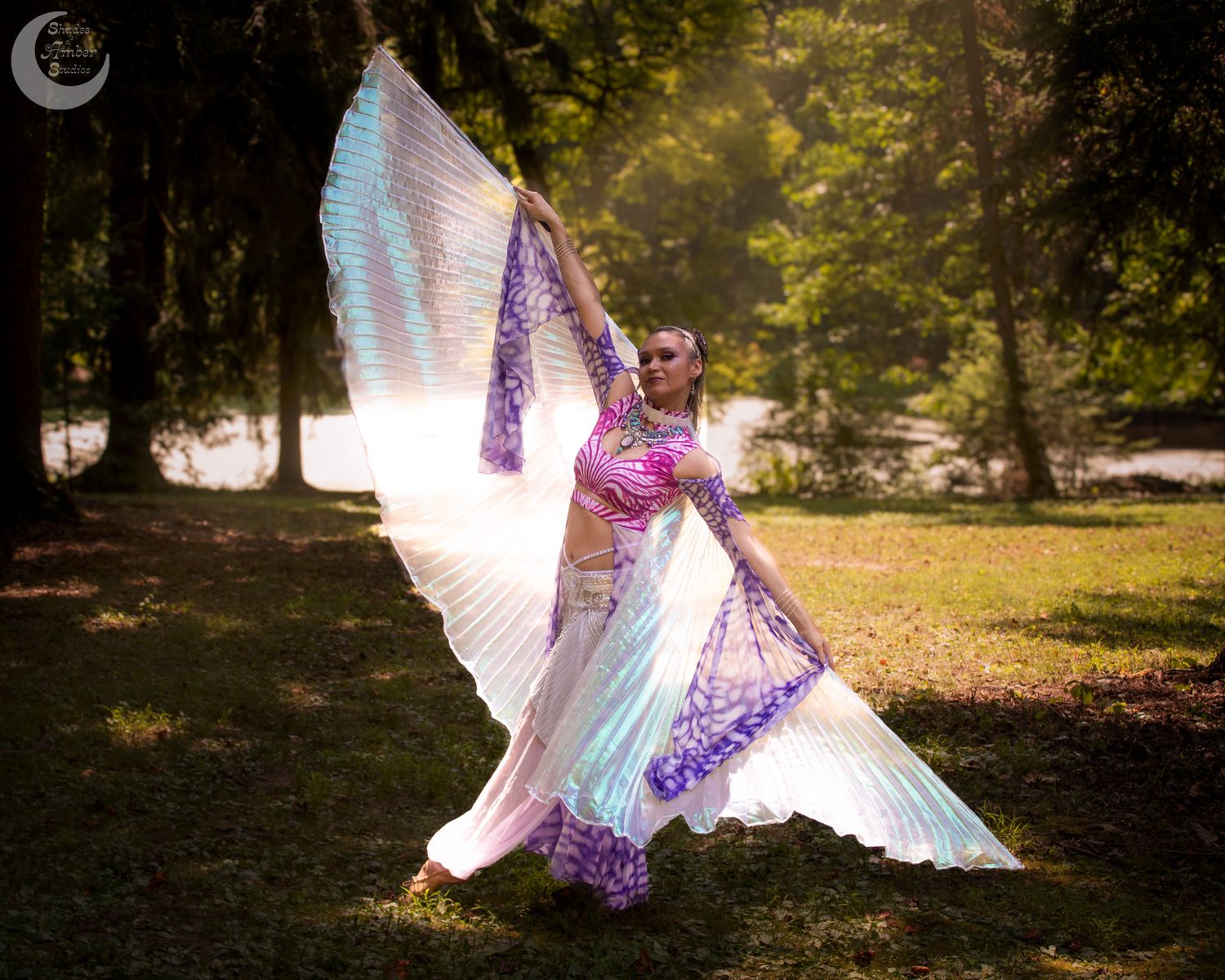 Flowing fabric wings create ethereal dance movements in a golden sunset forest scene.