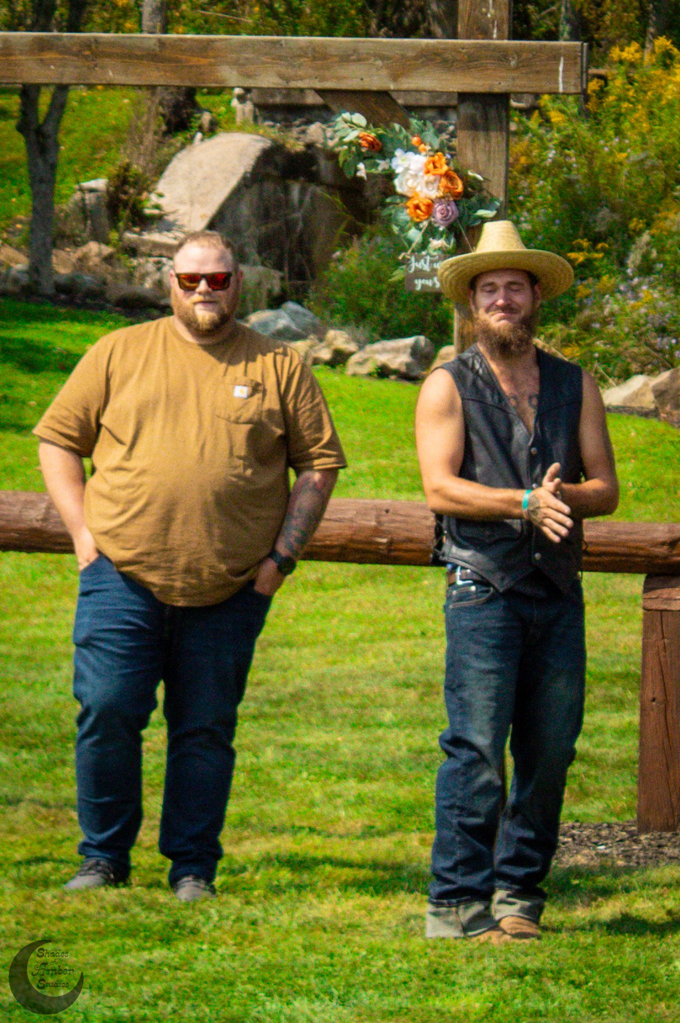 Two guests standing on grass at outdoor country wedding.
