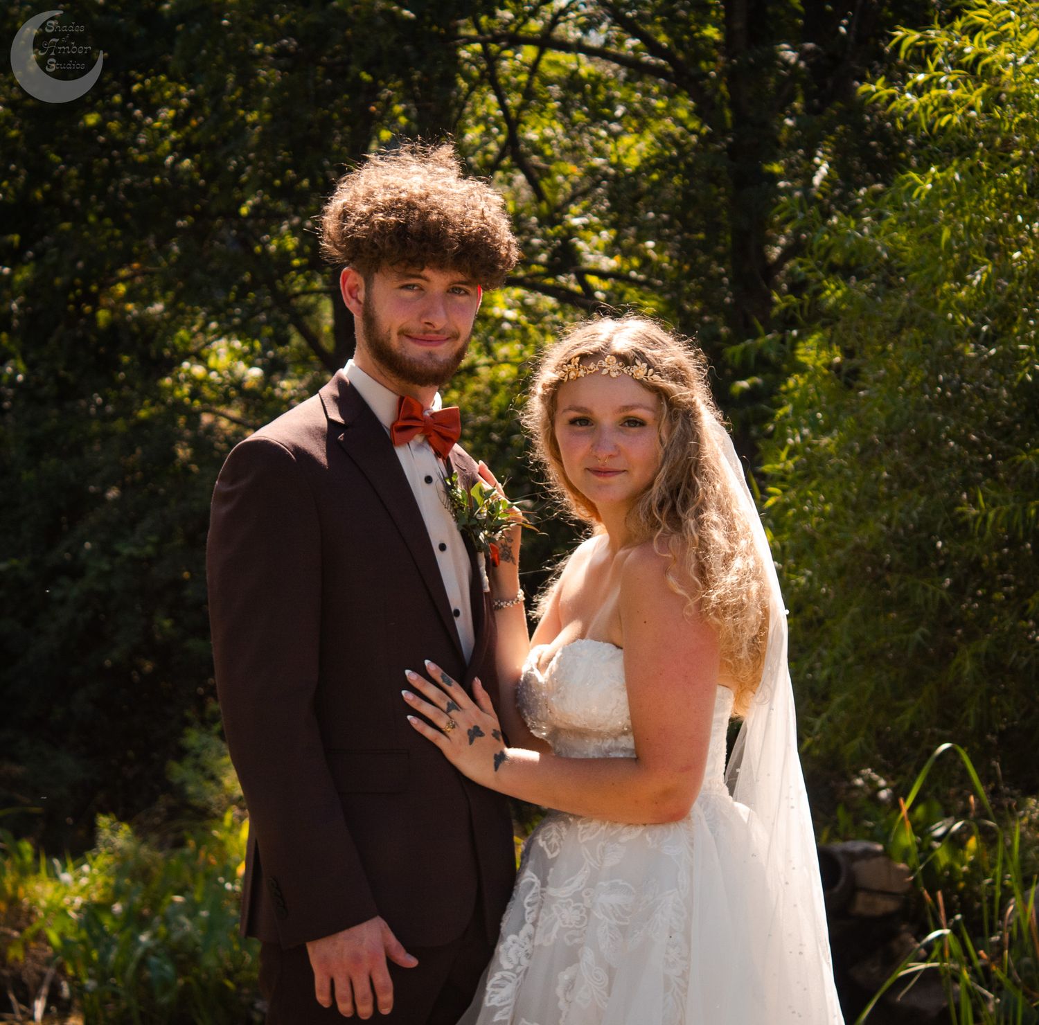 A couple sharing intimate moments during their wedding photoshoot in a lush garden setting.