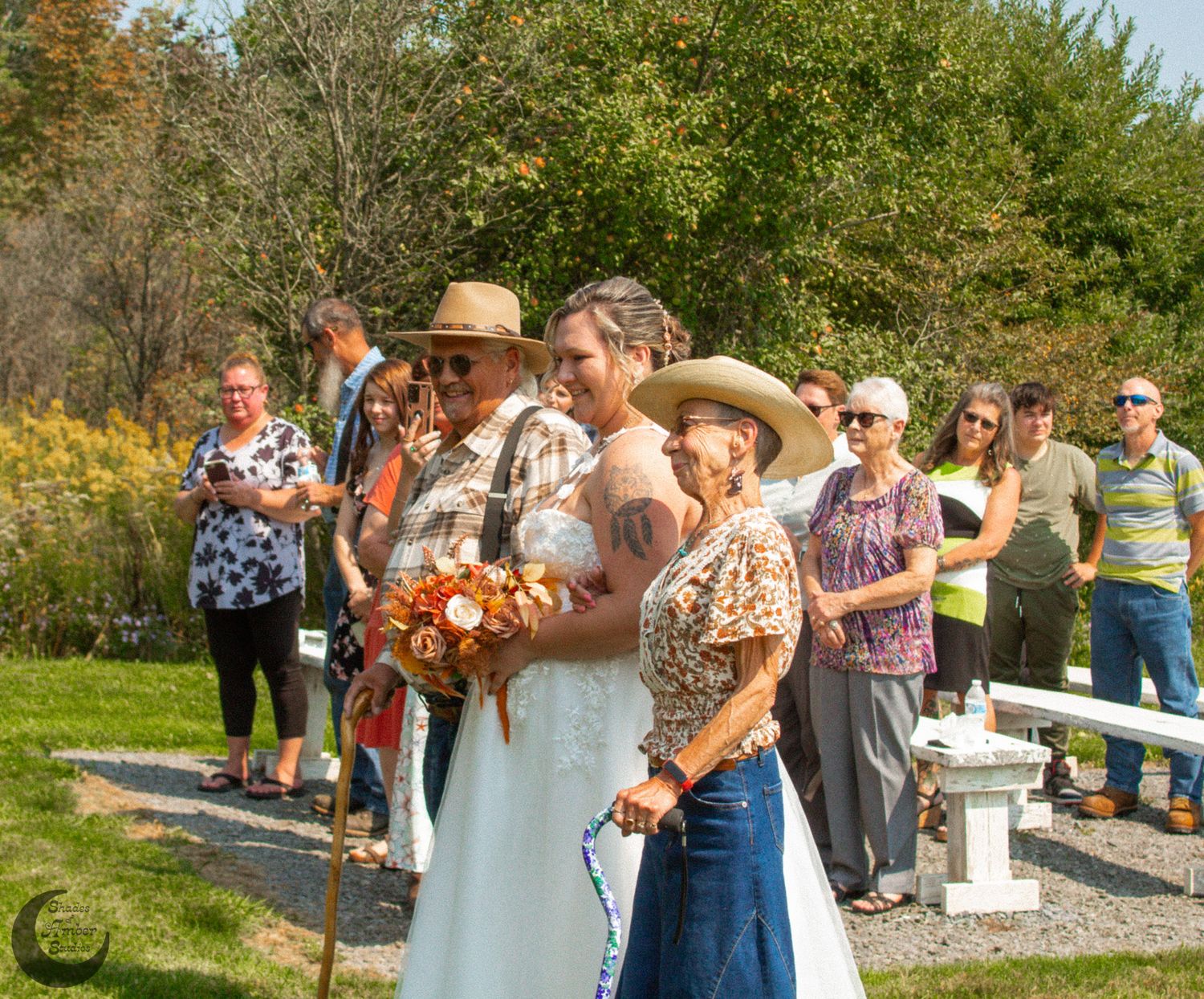 Wedding processional line at outdoor ceremony with autumn foliage.