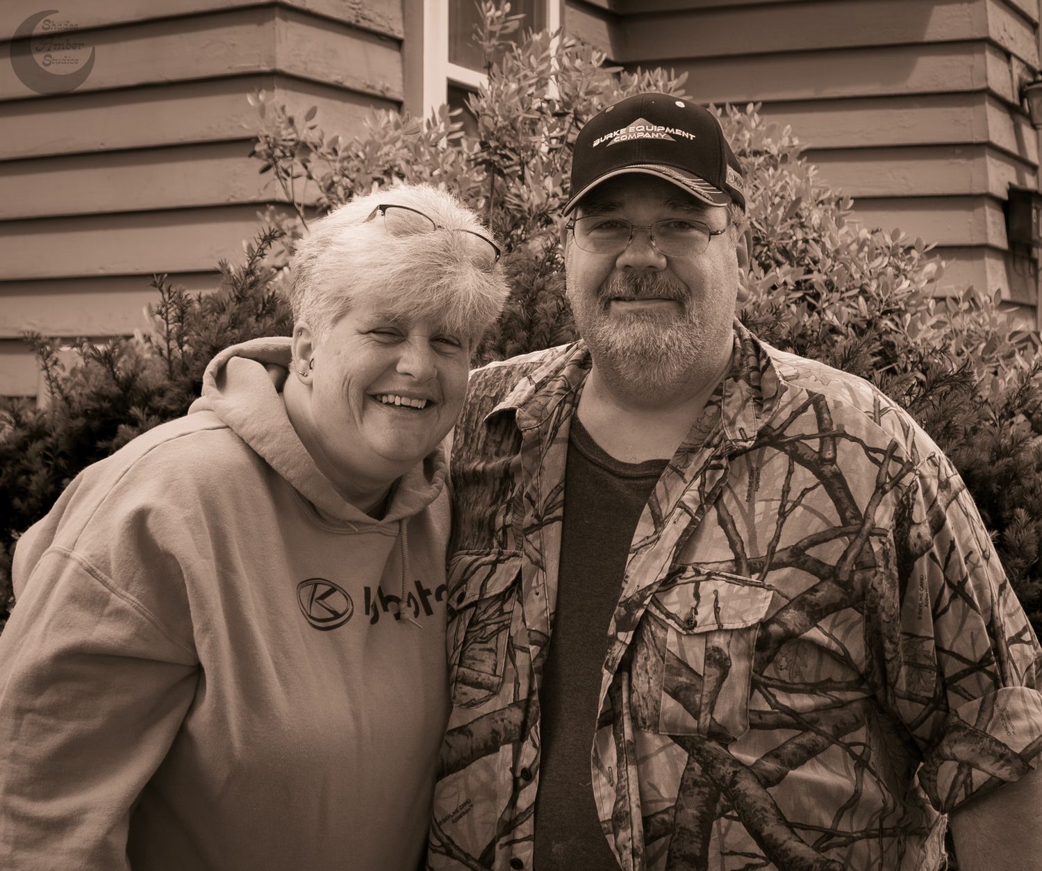 A series of black and white photos showing two people outdoors smiling together in casual attire.
