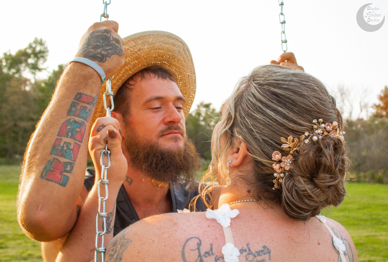 A wedding couple sharing a moment outdoors with decorative hanging lights.