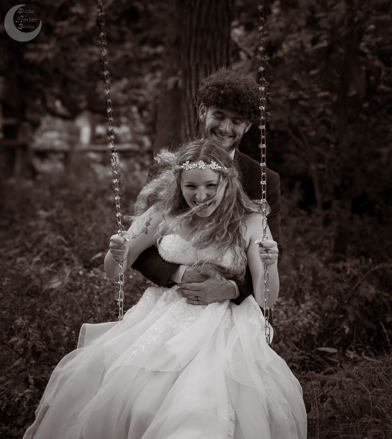 A joyful moment captured at a vintage-style wedding with a bride in white on a rustic wooden swing.