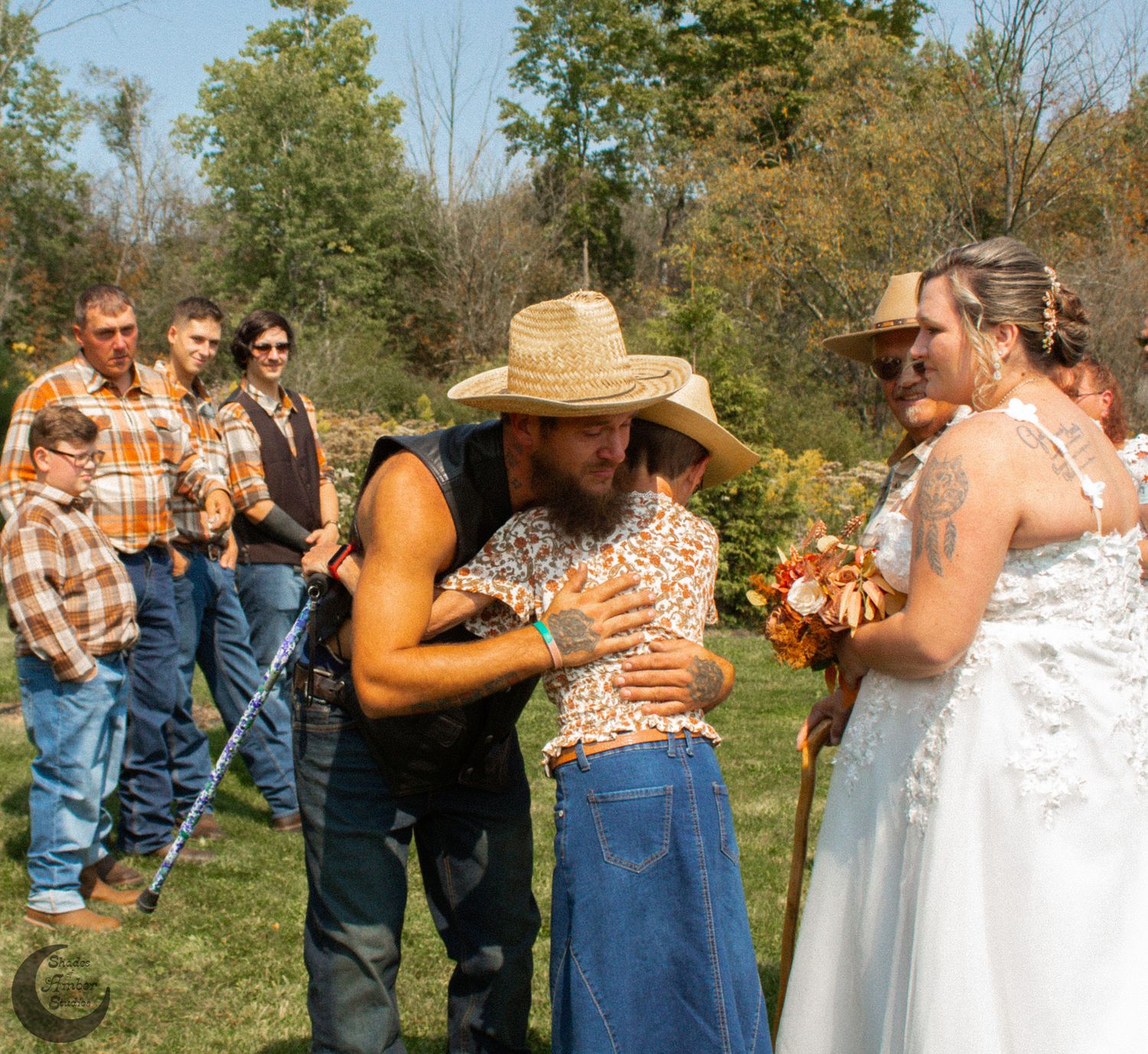 Casual country wedding ceremony in progress with natural outdoor backdrop.
