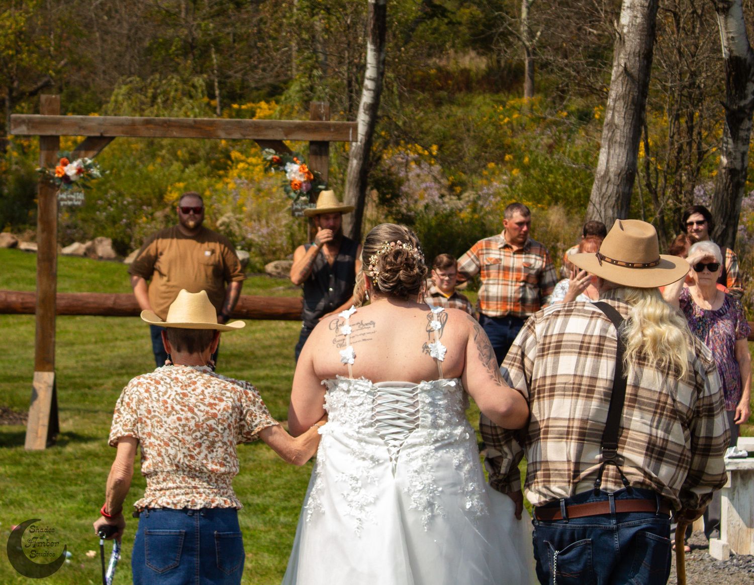Outdoor wedding ceremony gathering with rustic country attire.