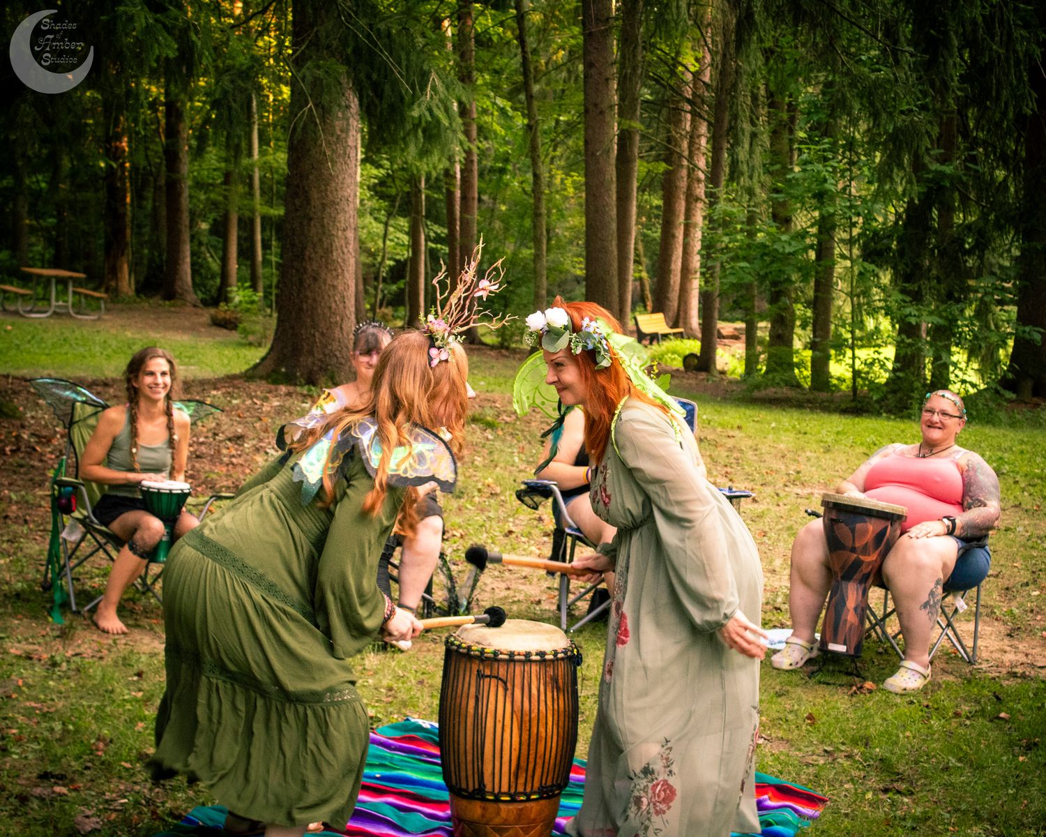Dancing figures in medieval costumes move in a circle during an outdoor festival performance.