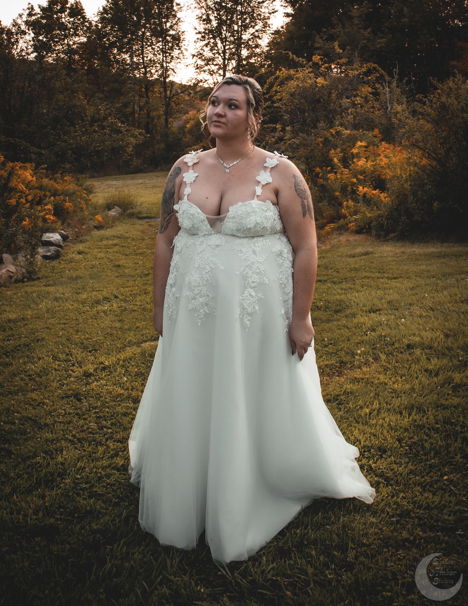 A wedding portrait showcasing an elegant white lace gown in a golden sunset meadow setting.