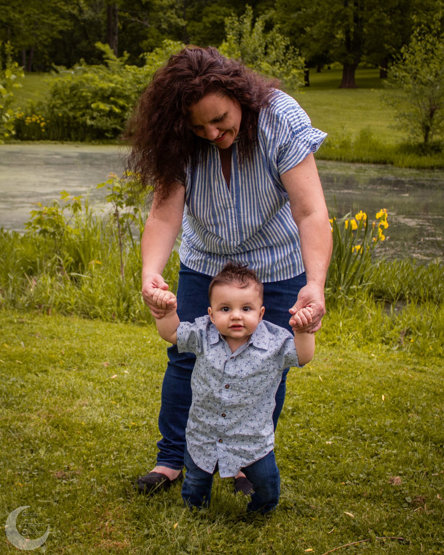 Outdoor family photoshoot in a grassy field with yellow flowers and natural scenery.