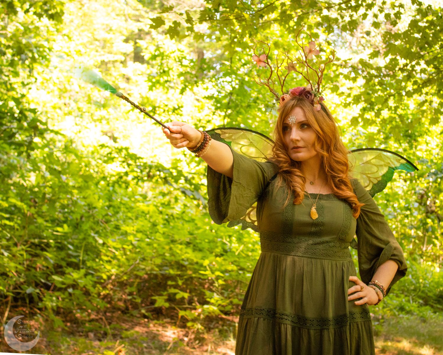 Forest photoshoot featuring olive green dress against sunlit foliage.