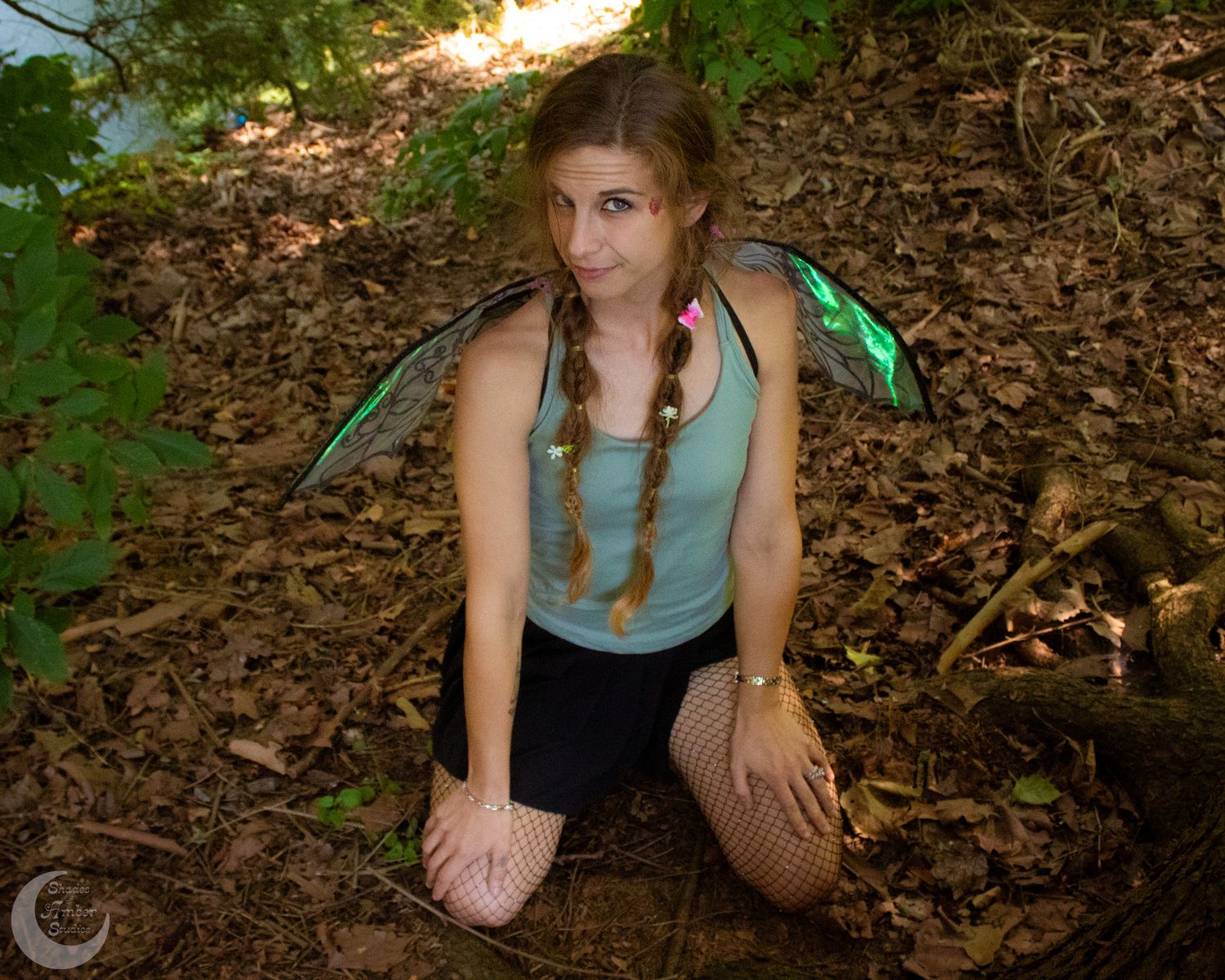 Artistic poses performed on fallen autumn leaves in a sunlit wooded area.