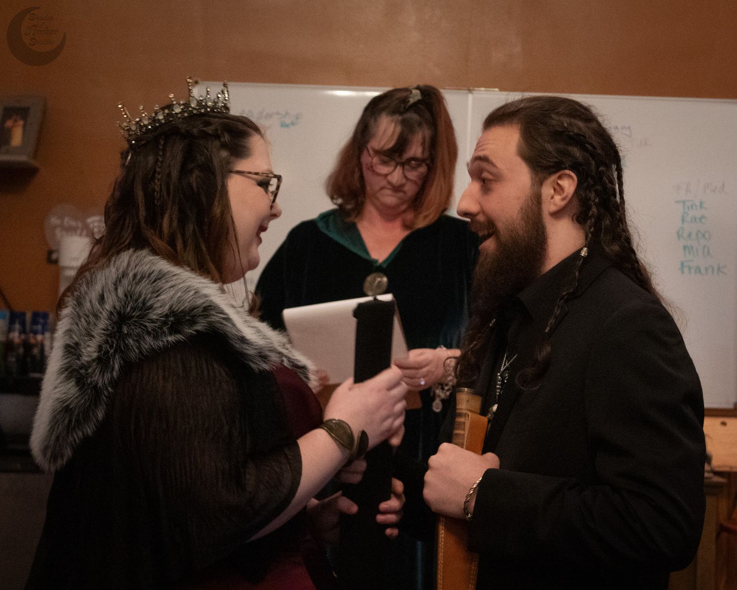 An intimate ceremony moment as participants exchange vows with candles in the background.