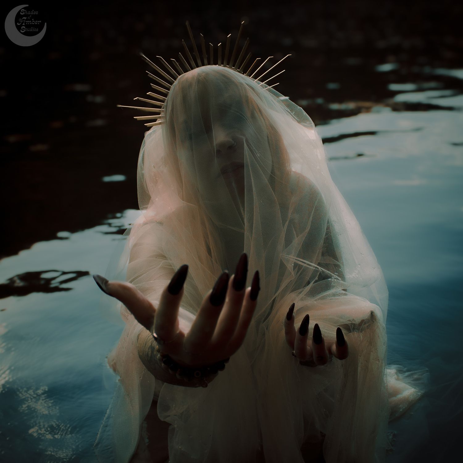 Mystical figure in flowing veil with spiked crown emerges from dark waters.