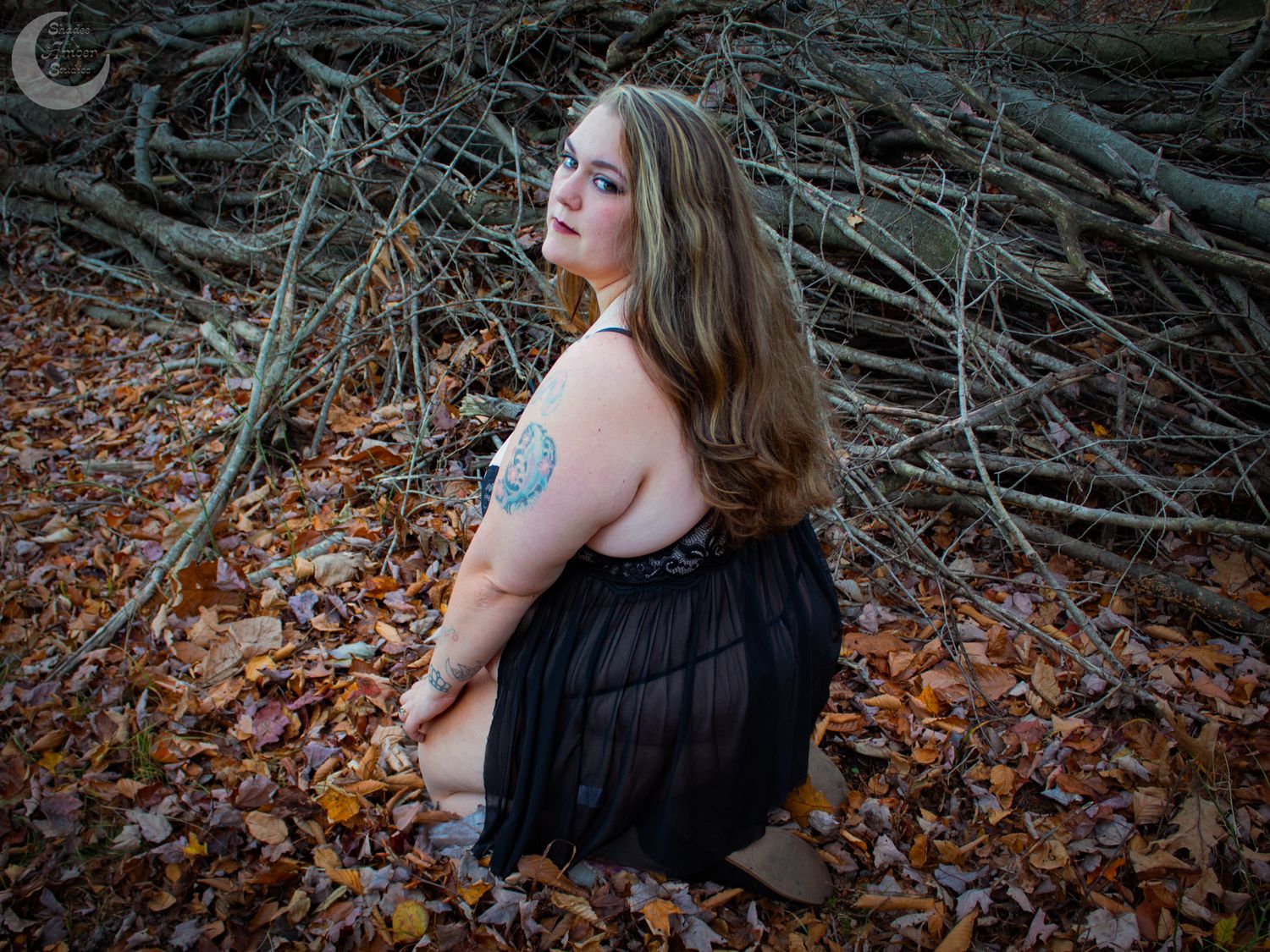 A woodland photoshoot scene with fallen leaves and natural autumn lighting.