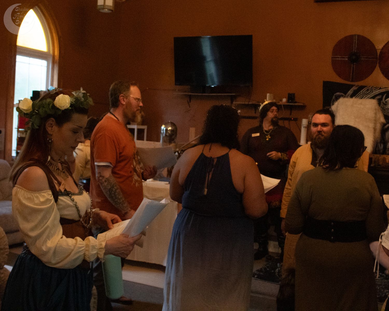 A dimly lit performance venue or theater space with people seated in rows and warm lighting creating an intimate atmosphere.