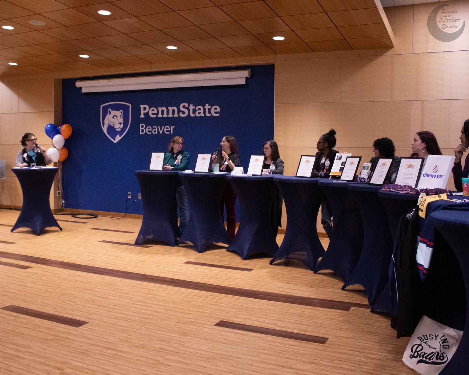 College career fair expo booths with representatives at tables along a wall in a conference room.