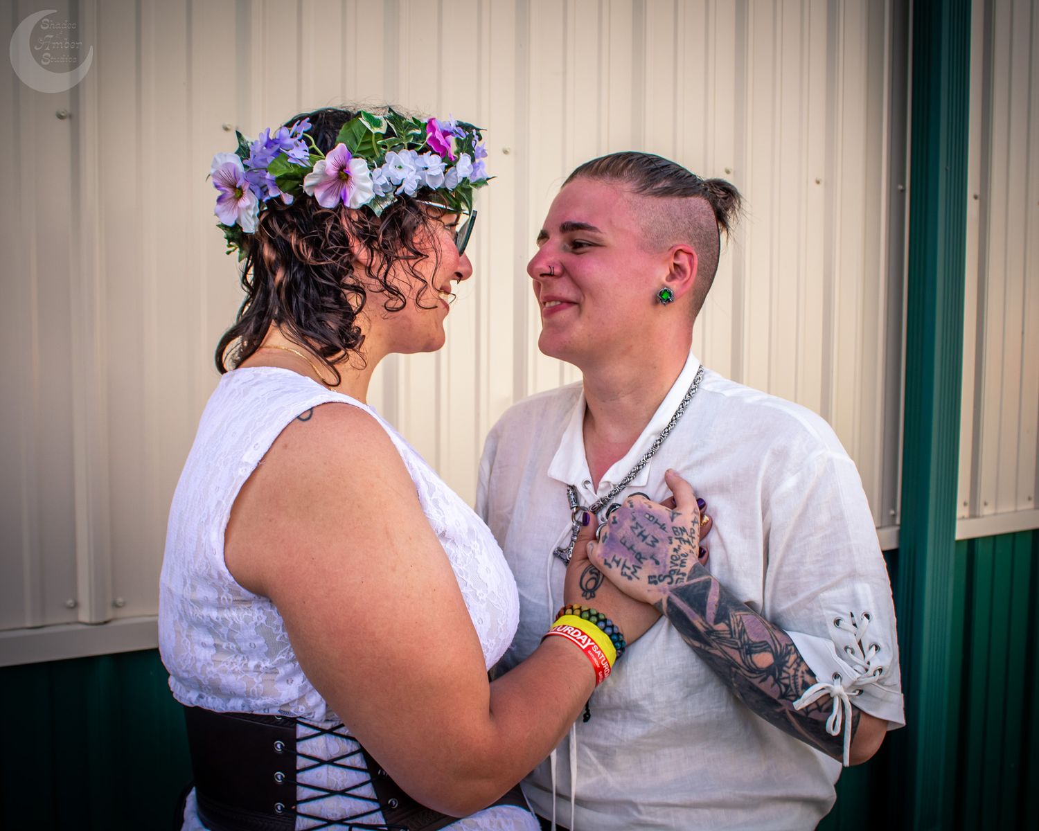 A couple in white attire shares multiple romantic moments in front of a light-colored wall.