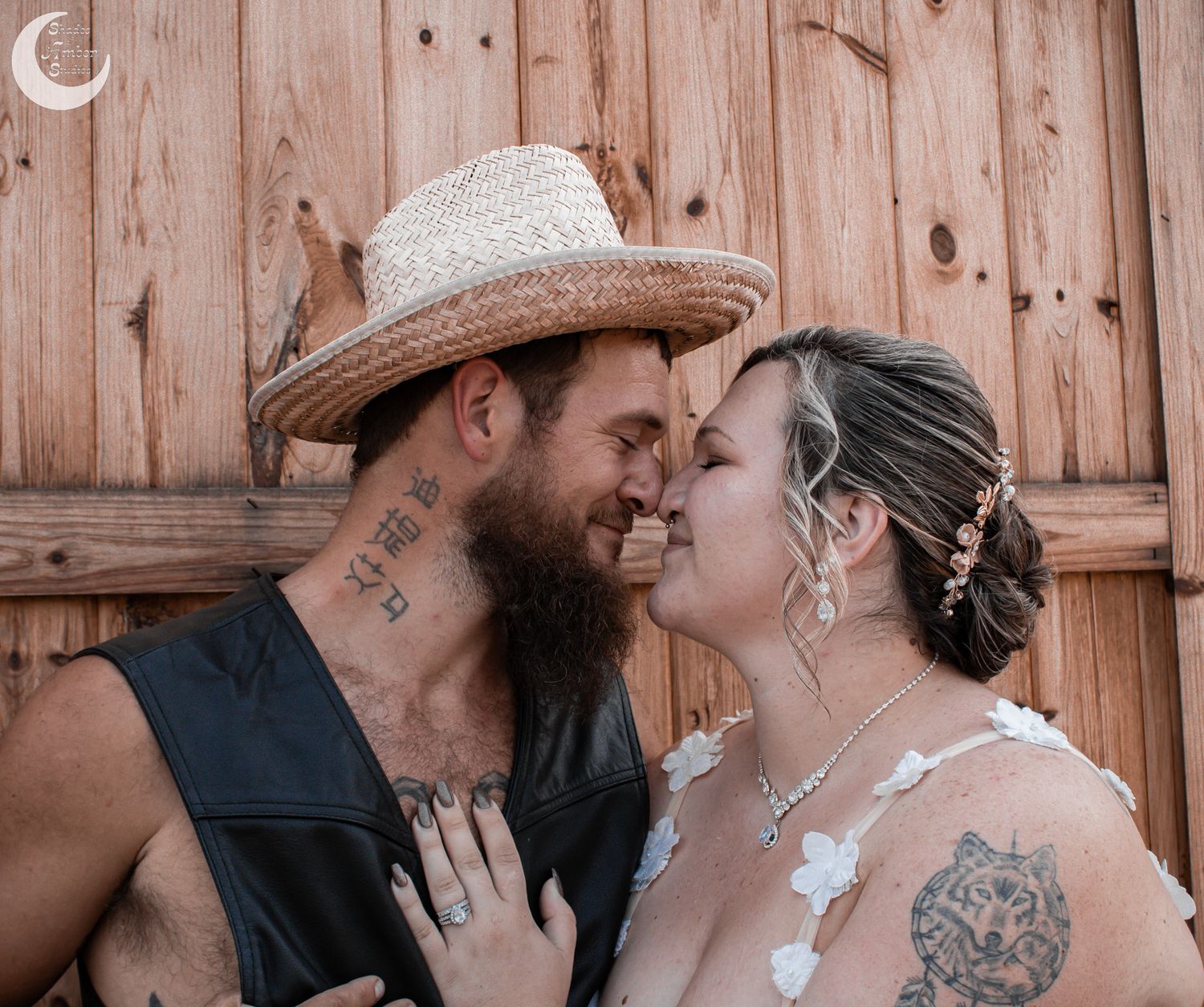 An intimate wedding portrait against a wooden wall background.