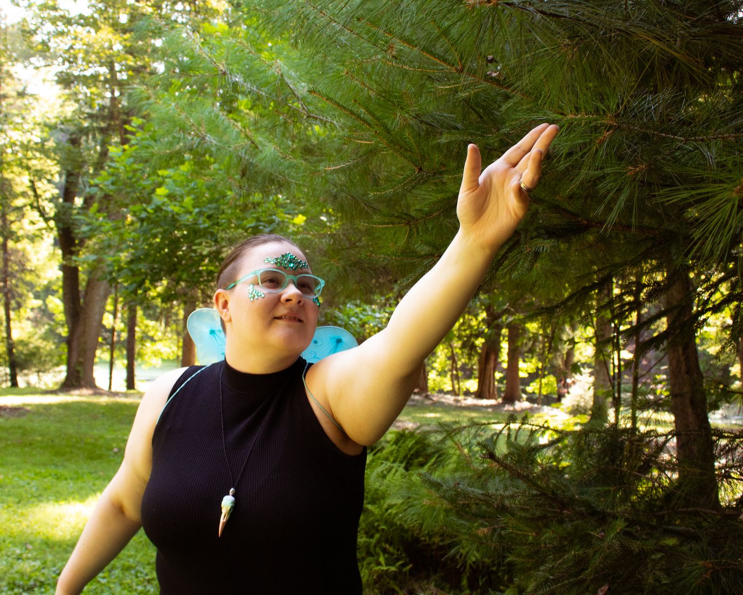 Dance-like movements captured in a forest setting with sunlight filtering through green trees.