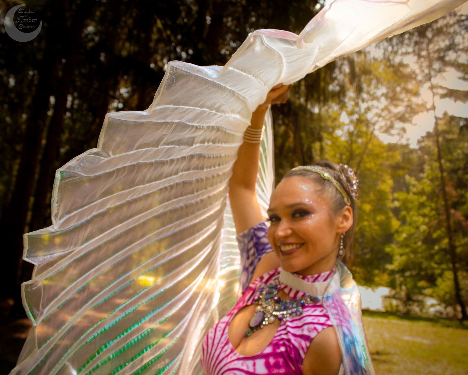 Shimmering wings catch sunlight in enchanting forest photoshoot scene.