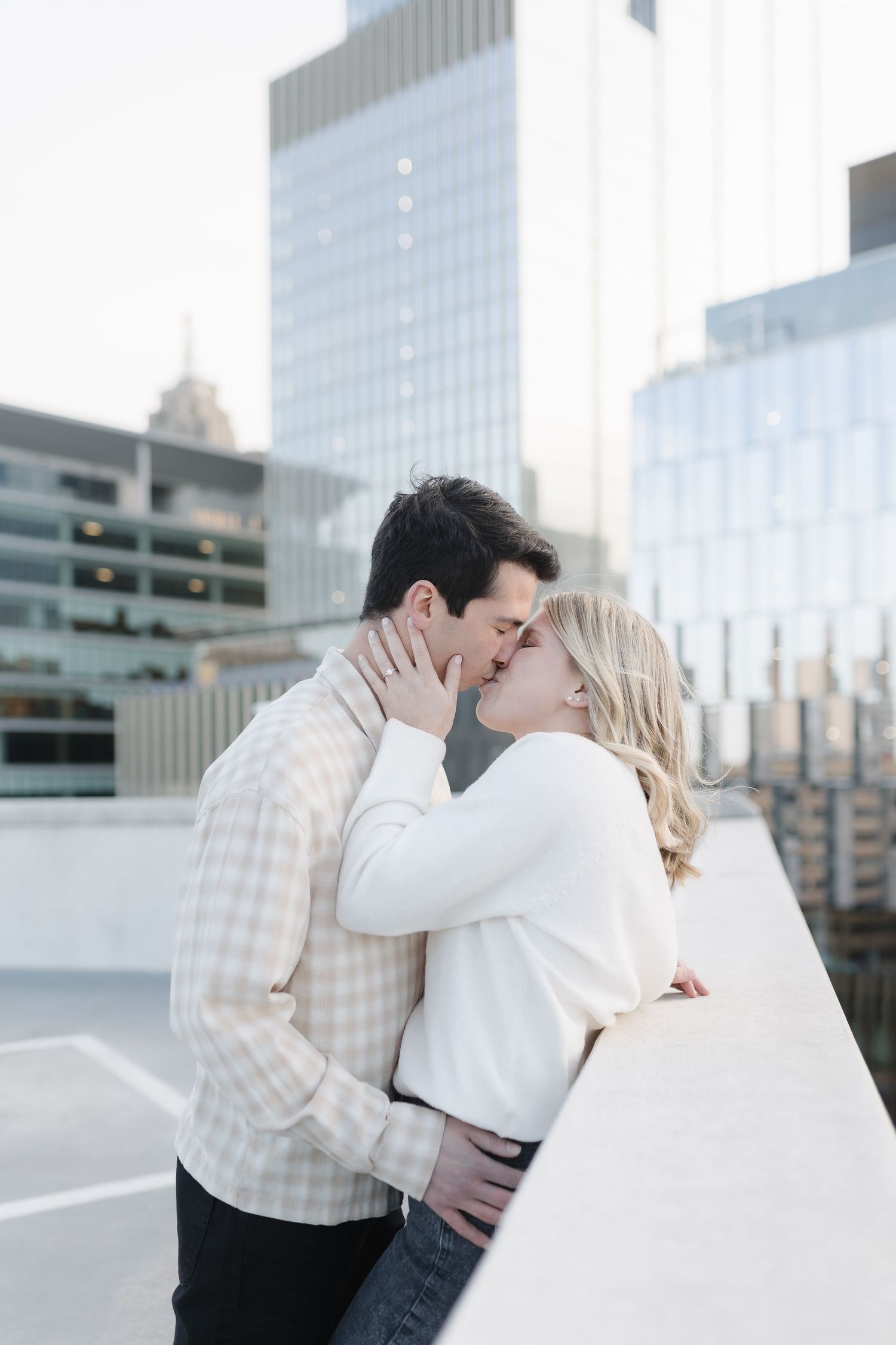 A romantic moment shared on an urban rooftop with city buildings in the background.