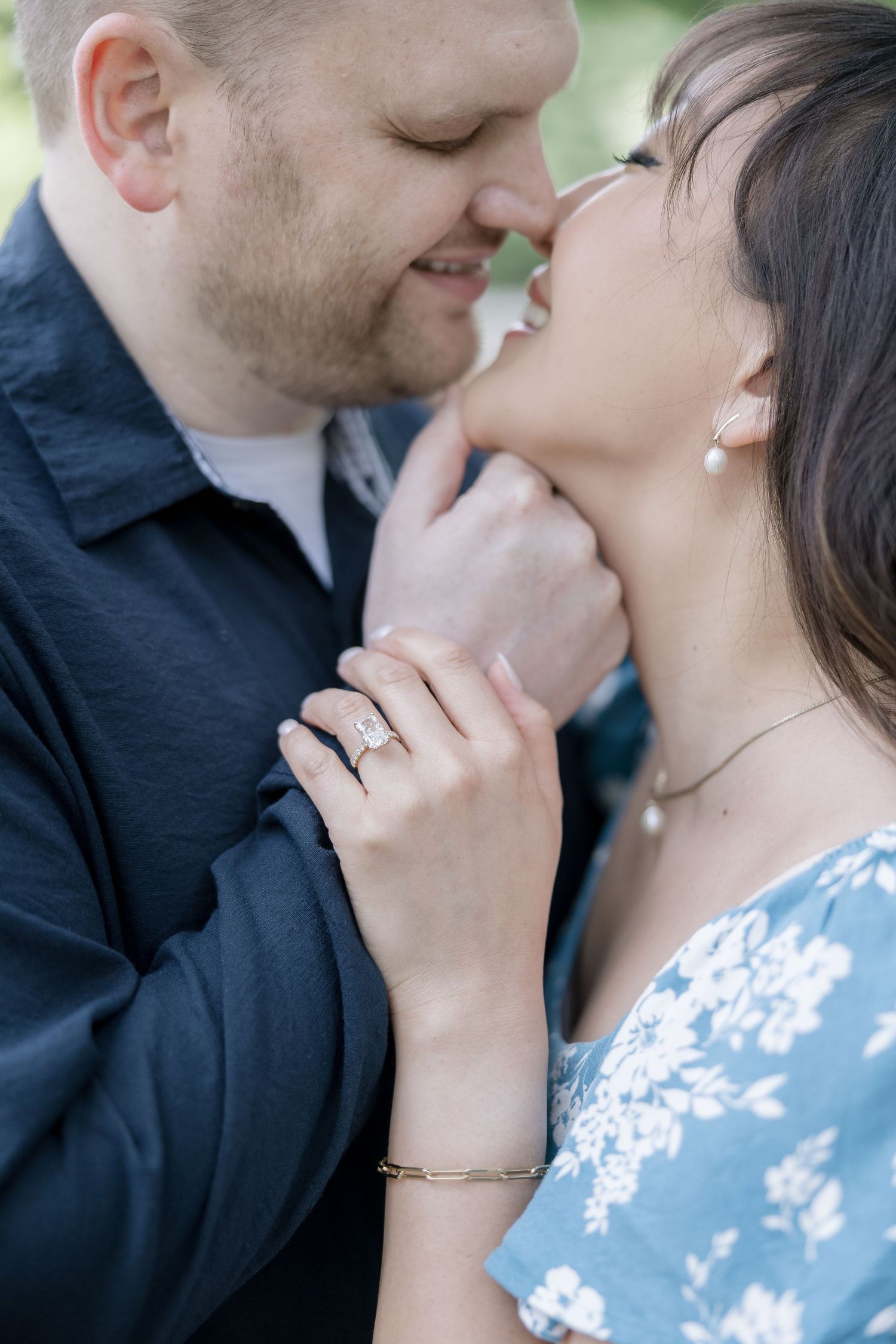An intimate close-up moment between a couple wearing blue and black clothing outdoors.
