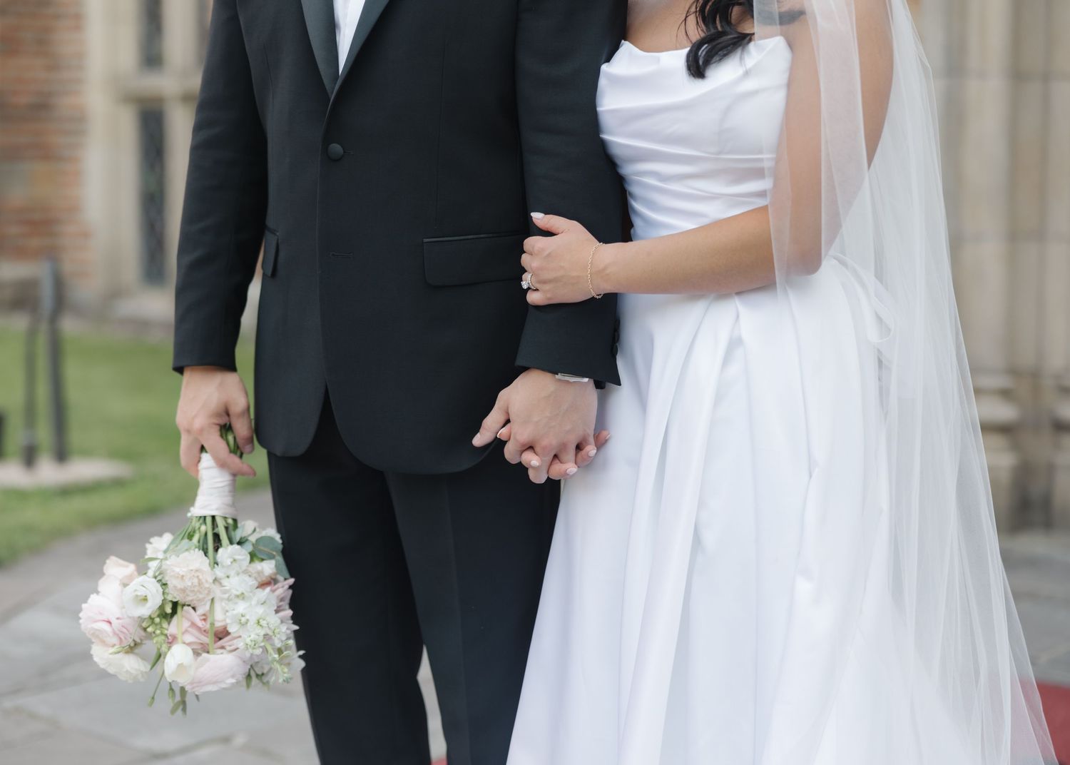 Wedding couple and party members in formal attire standing outdoors.