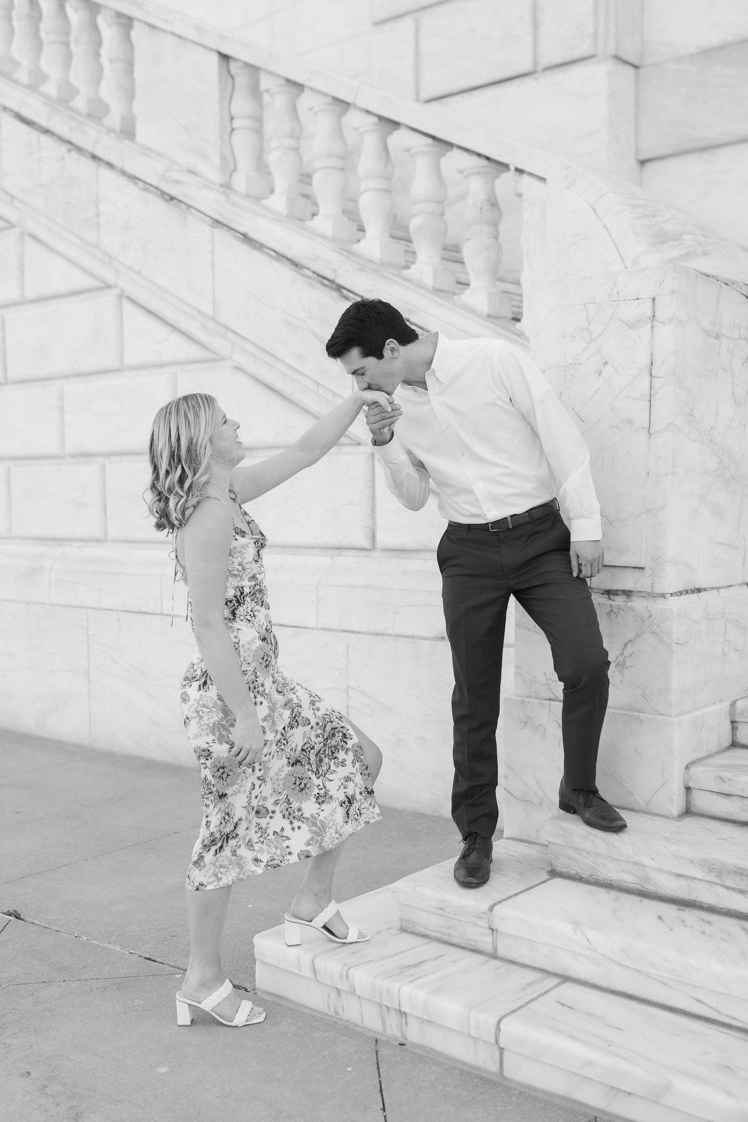 A romantic dance pose on stone steps with a floral dress and formal attire.