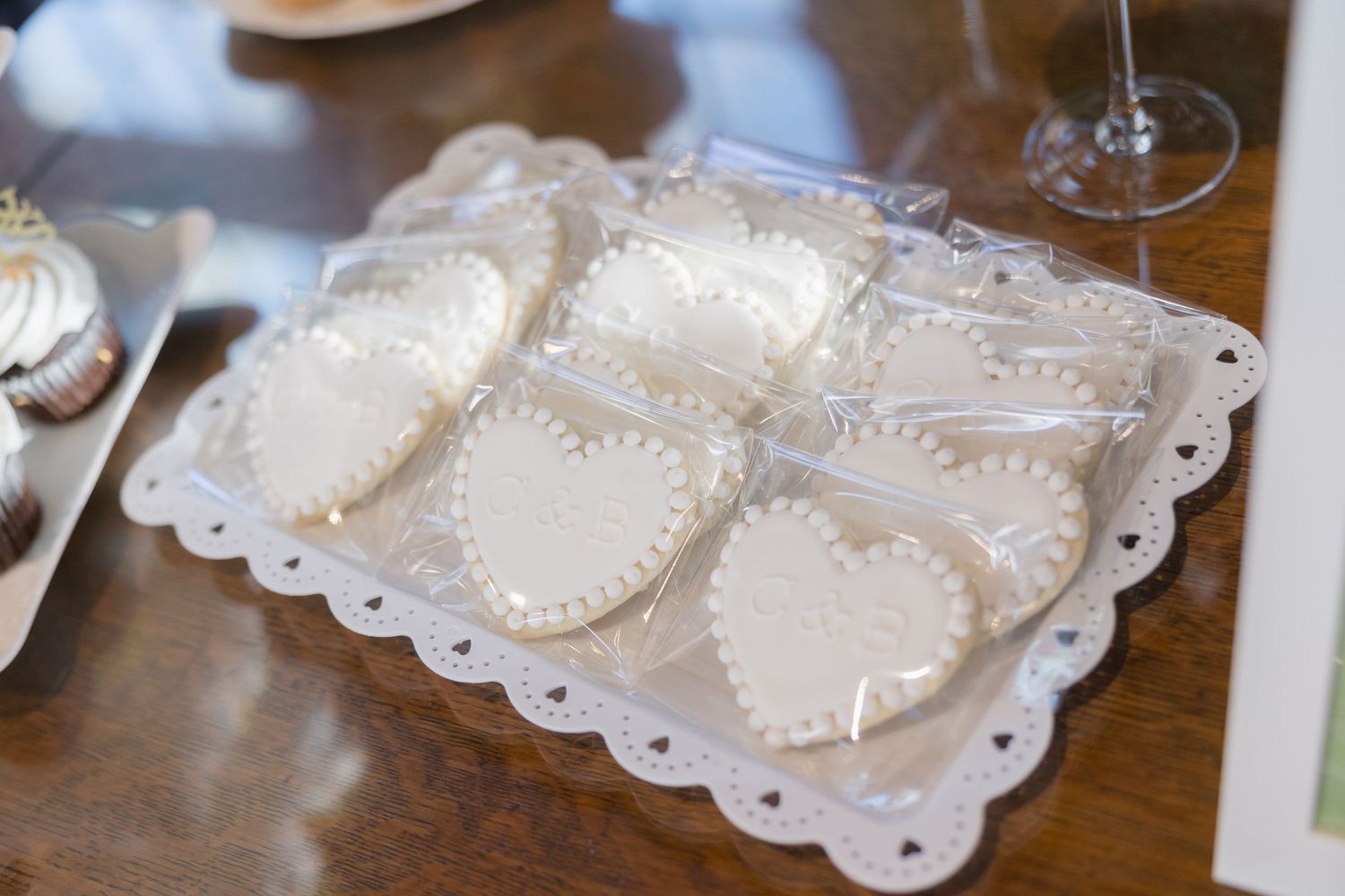 White heart-shaped cookies arranged on a decorative scalloped serving tray.