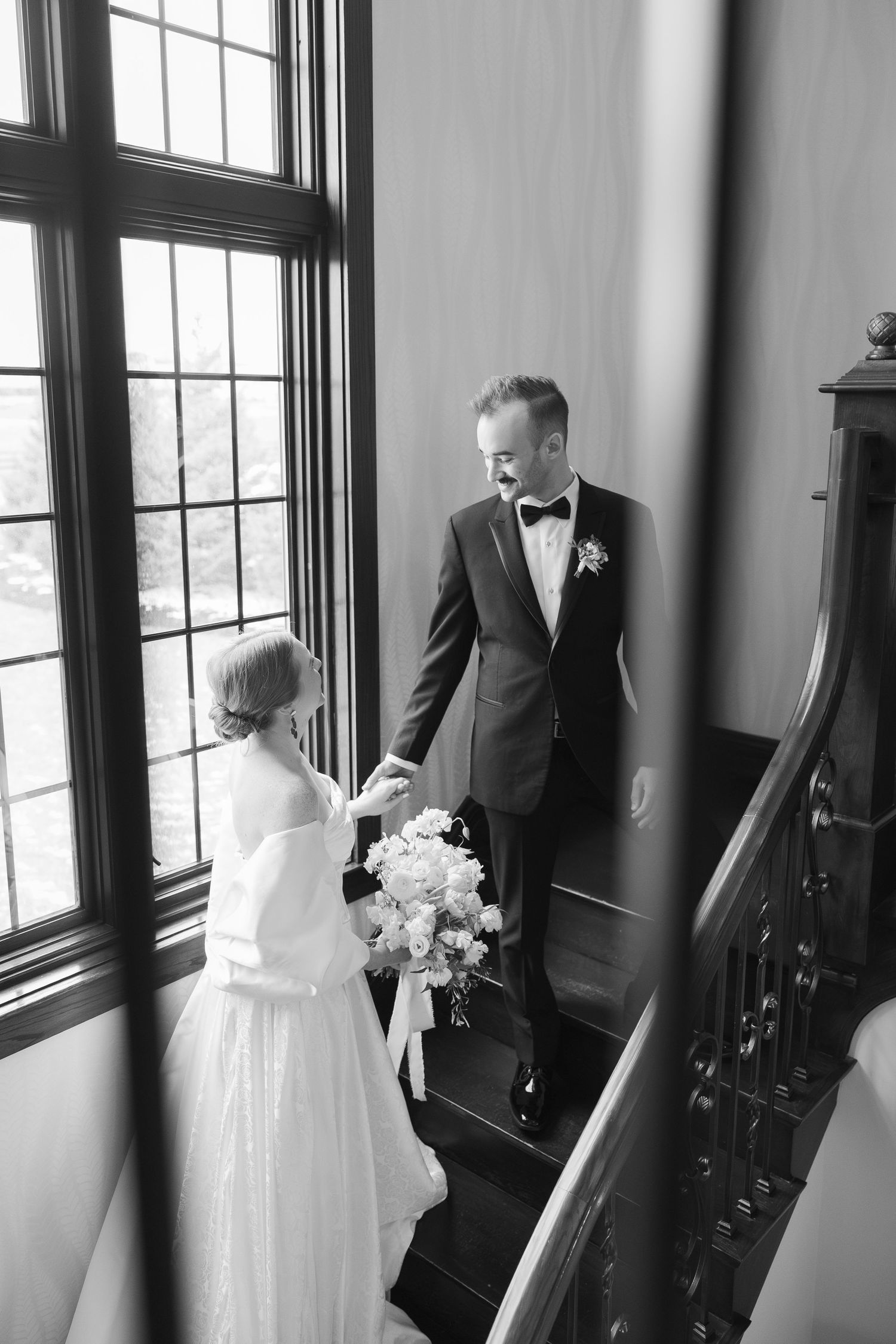 Black and white wedding photos showing tender moments between newlyweds in an elegant indoor setting.