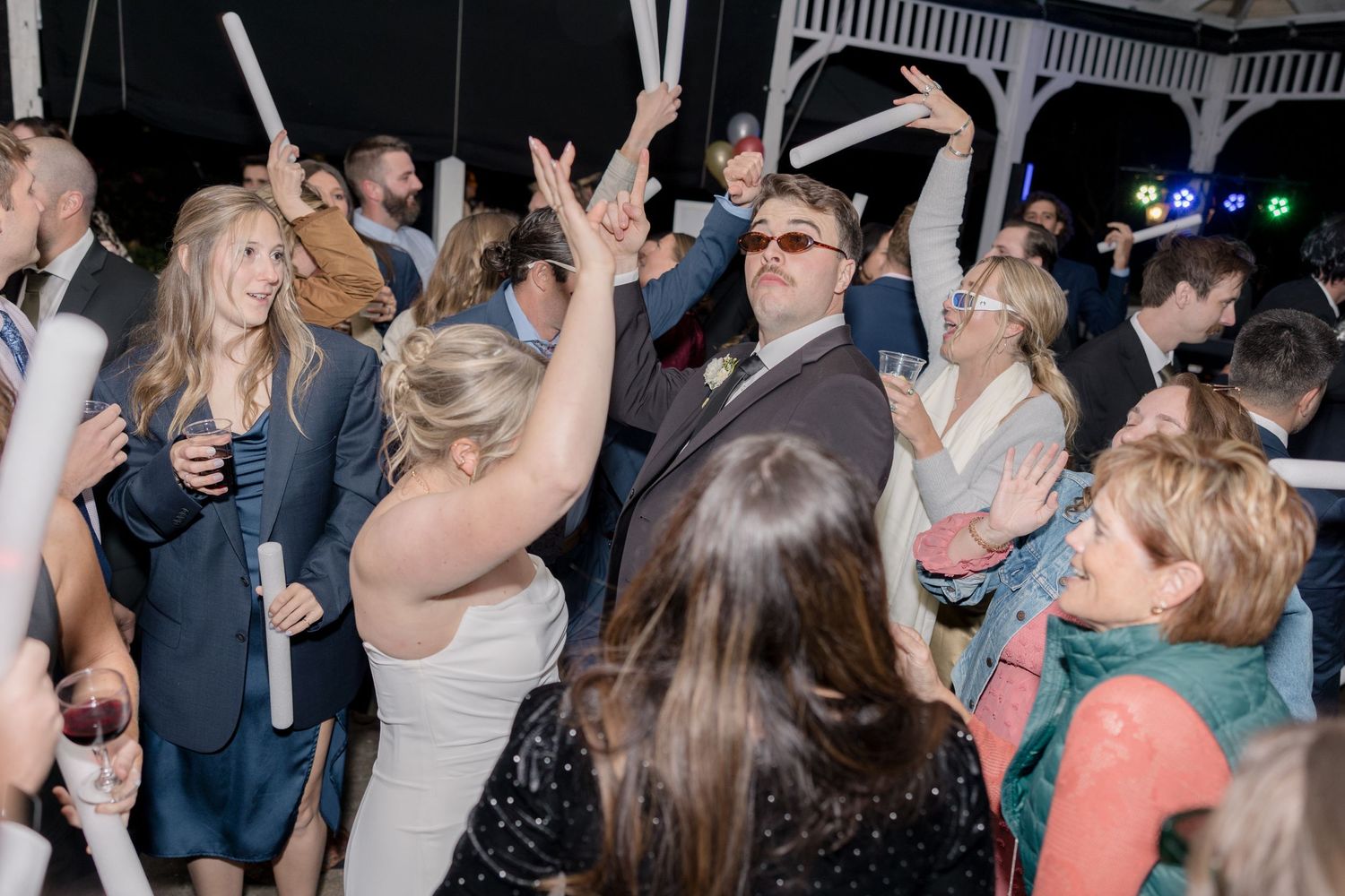 Lively dance floor with wedding guests dancing and celebrating.