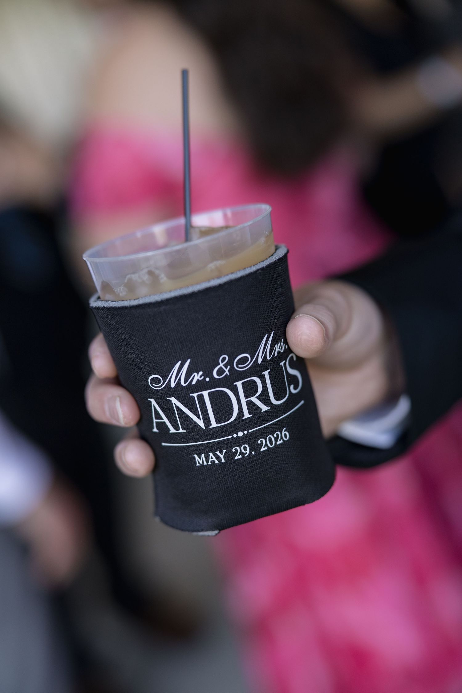 Black koozie reading Mr. & Mrs. Andrus May 29, 2026 held at a wedding reception.