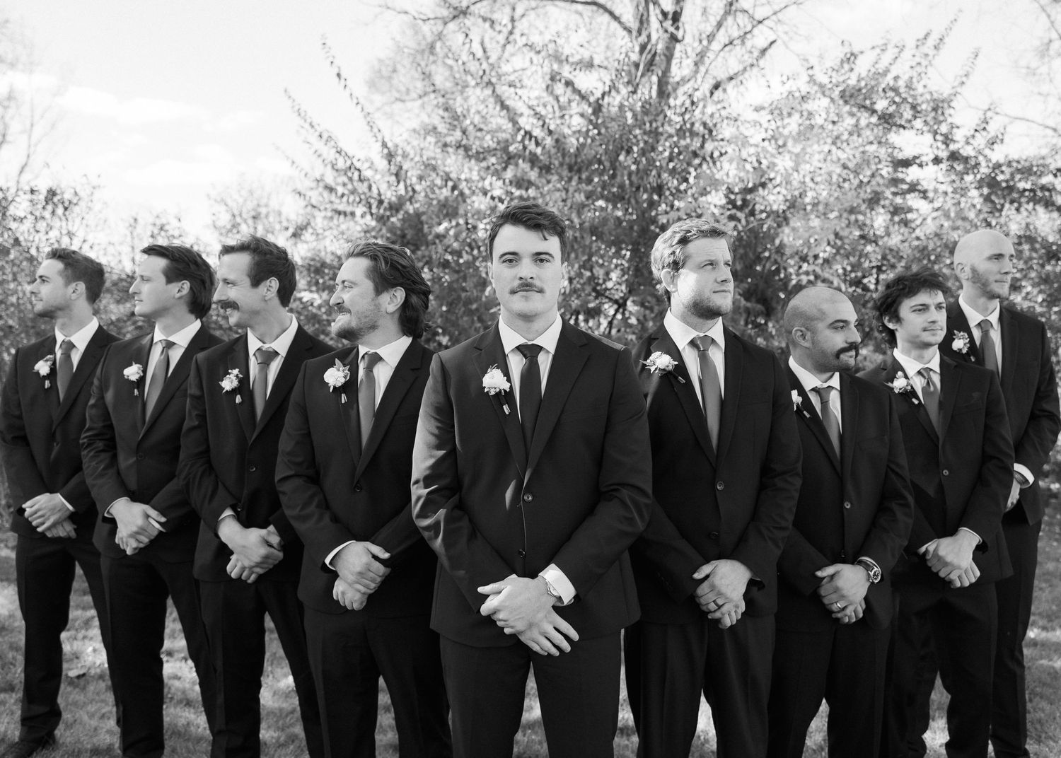 Classic black and white photo of groomsmen lined up in formal attire.