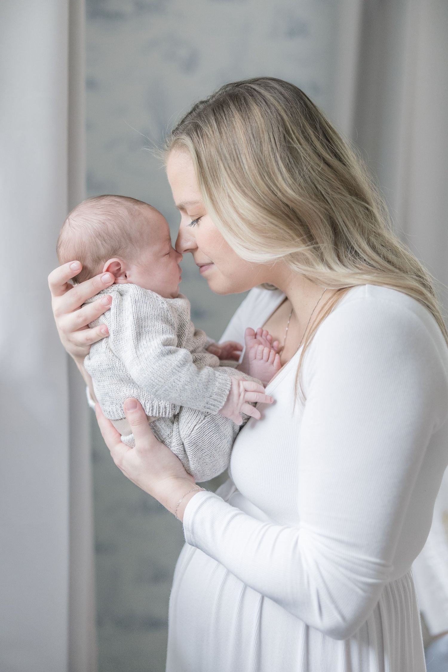 Tender portrait series of parent and newborn baby in soft white tones.