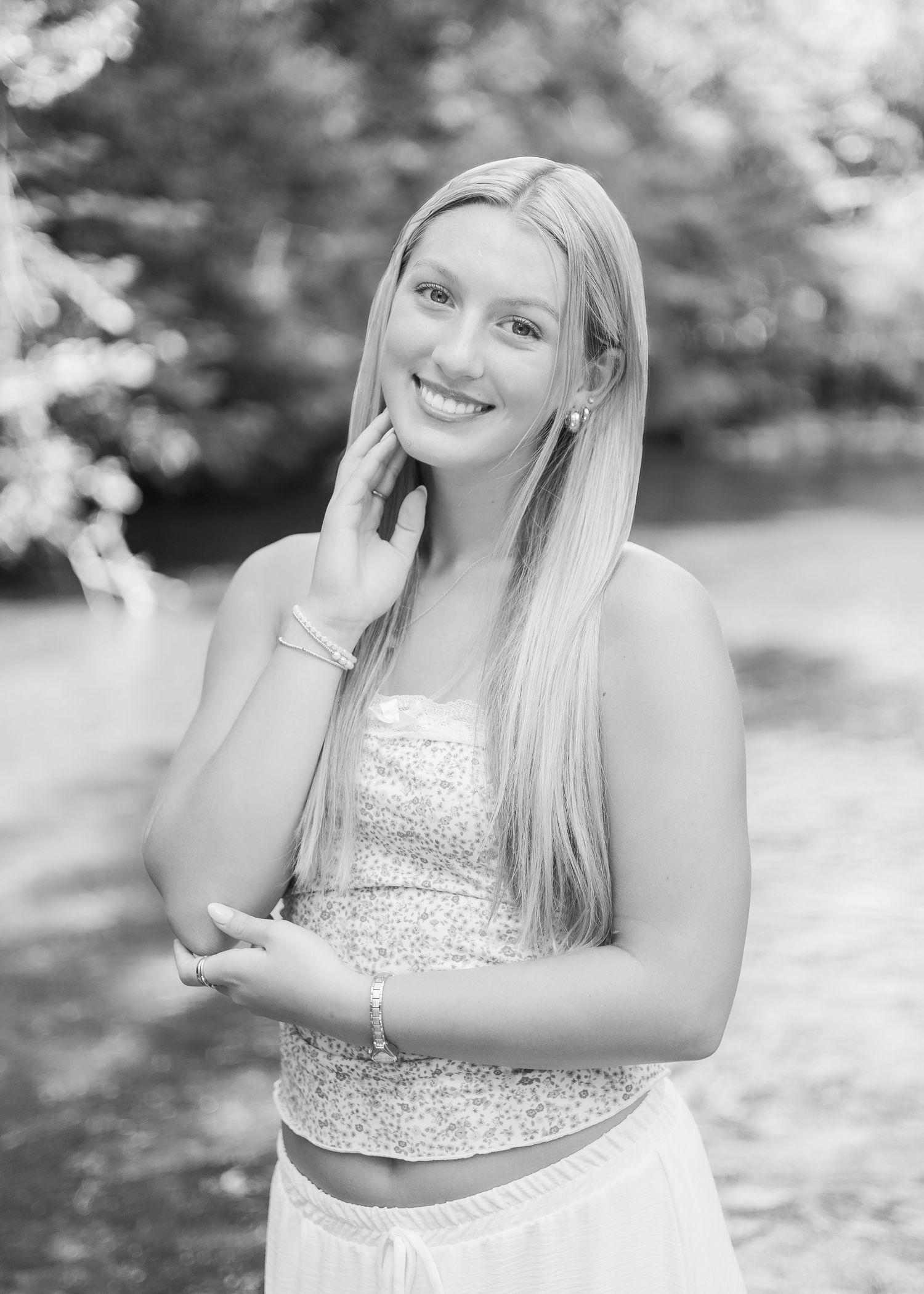 Series of black and white outdoor portraits showing someone in a sparkly top posing against a natural background.