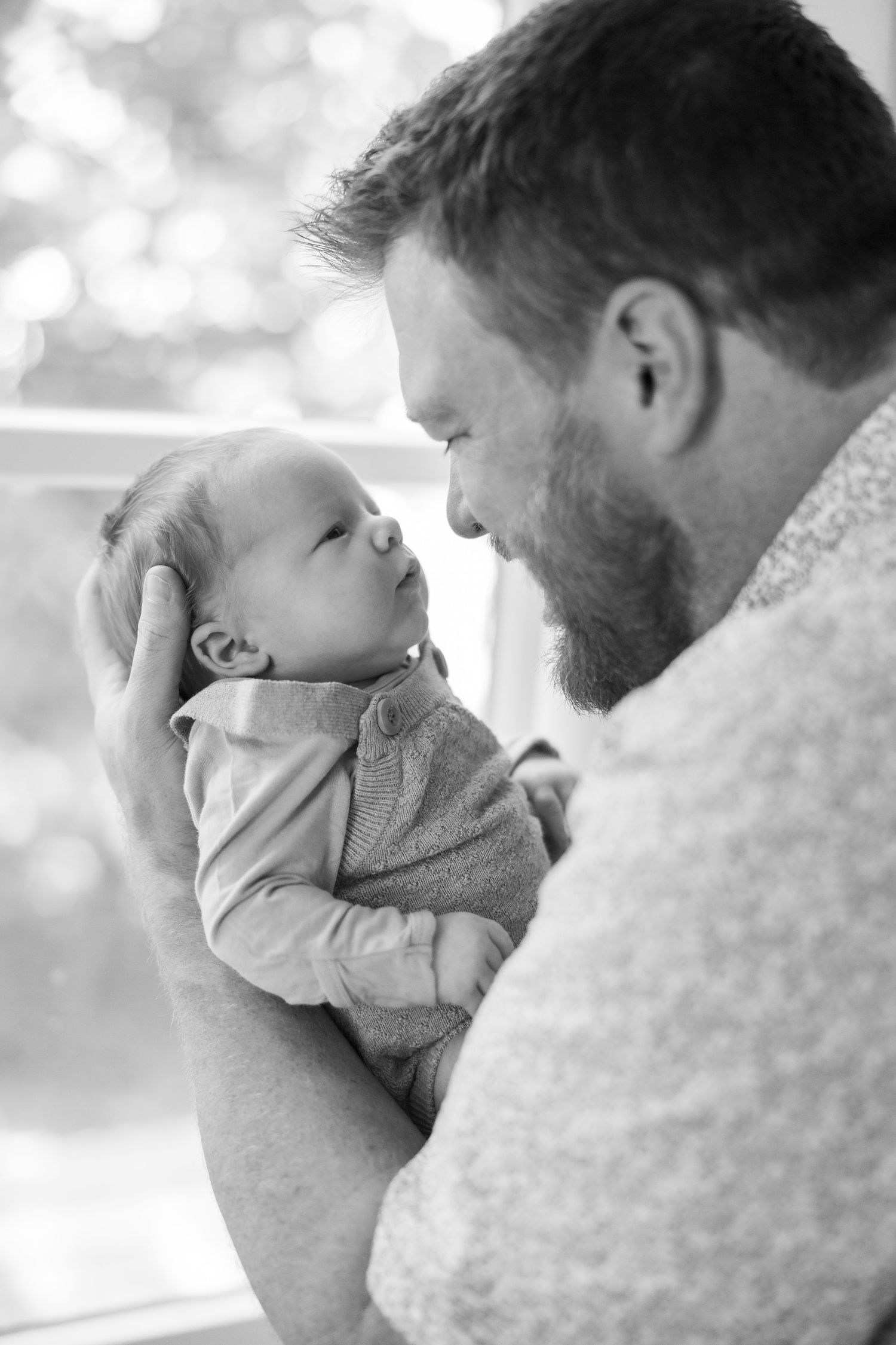 An intimate black and white portrait series showing tender family moments.